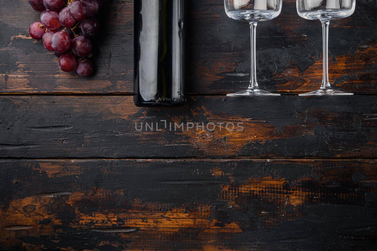 Red wine and grapes, on old dark wooden table , top view flat lay, with copy space for text by Ilianesolenyi