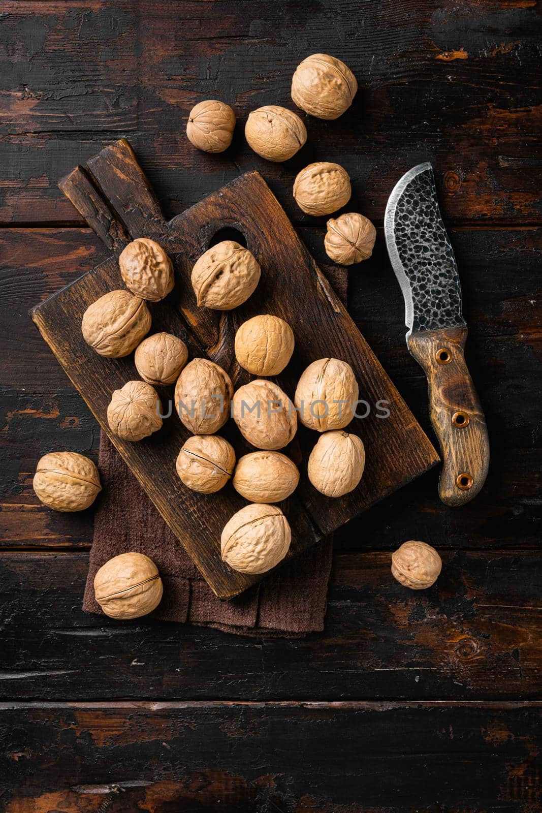 Whole organic walnuts set, on old dark wooden table background, top view flat lay