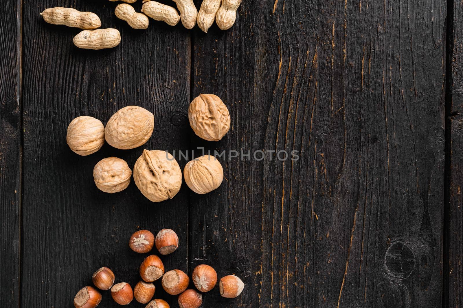 Walnut whole nut set, on black wooden table background, top view flat lay, with copy space for text