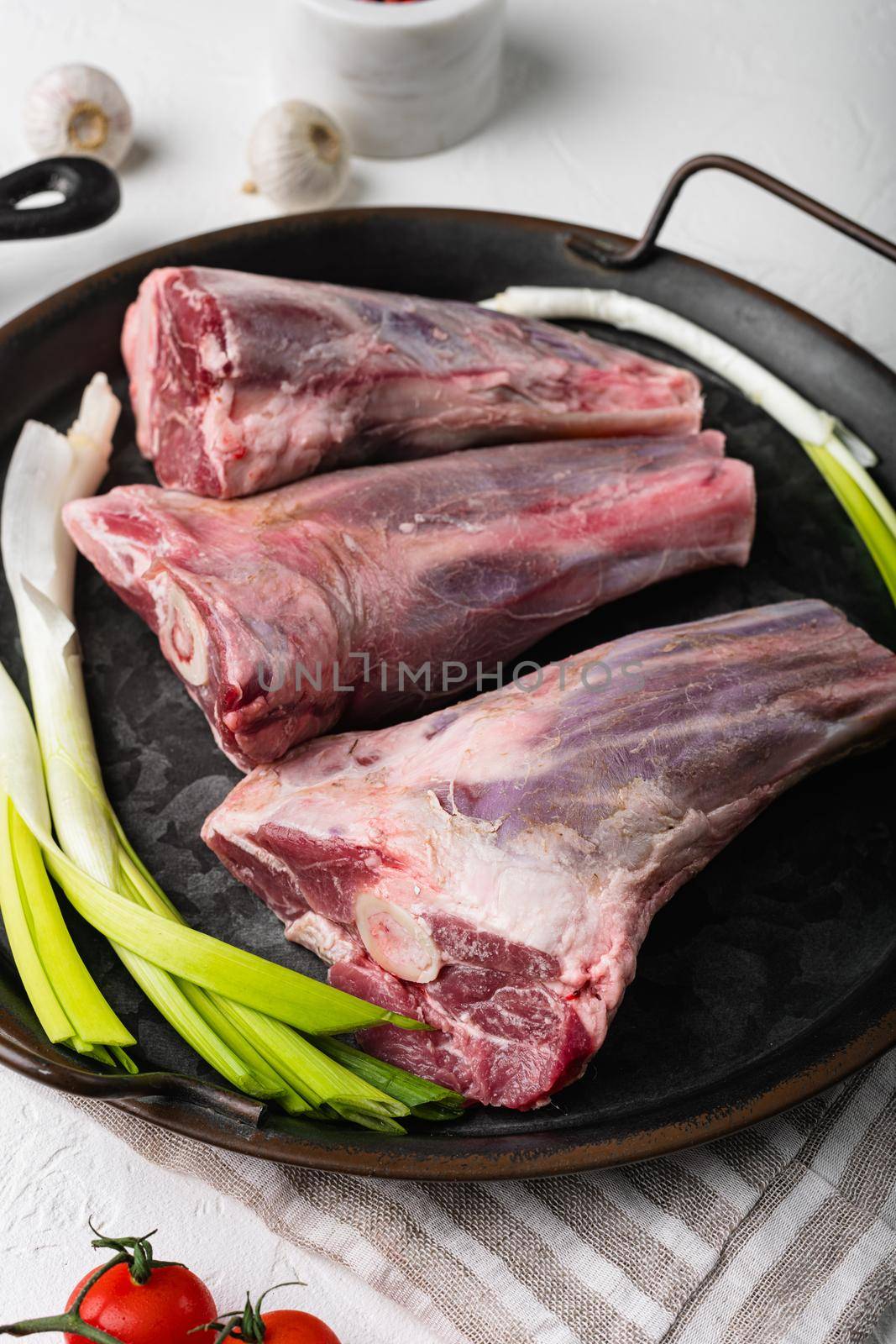 Fresh lamb shank, on white stone table background by Ilianesolenyi