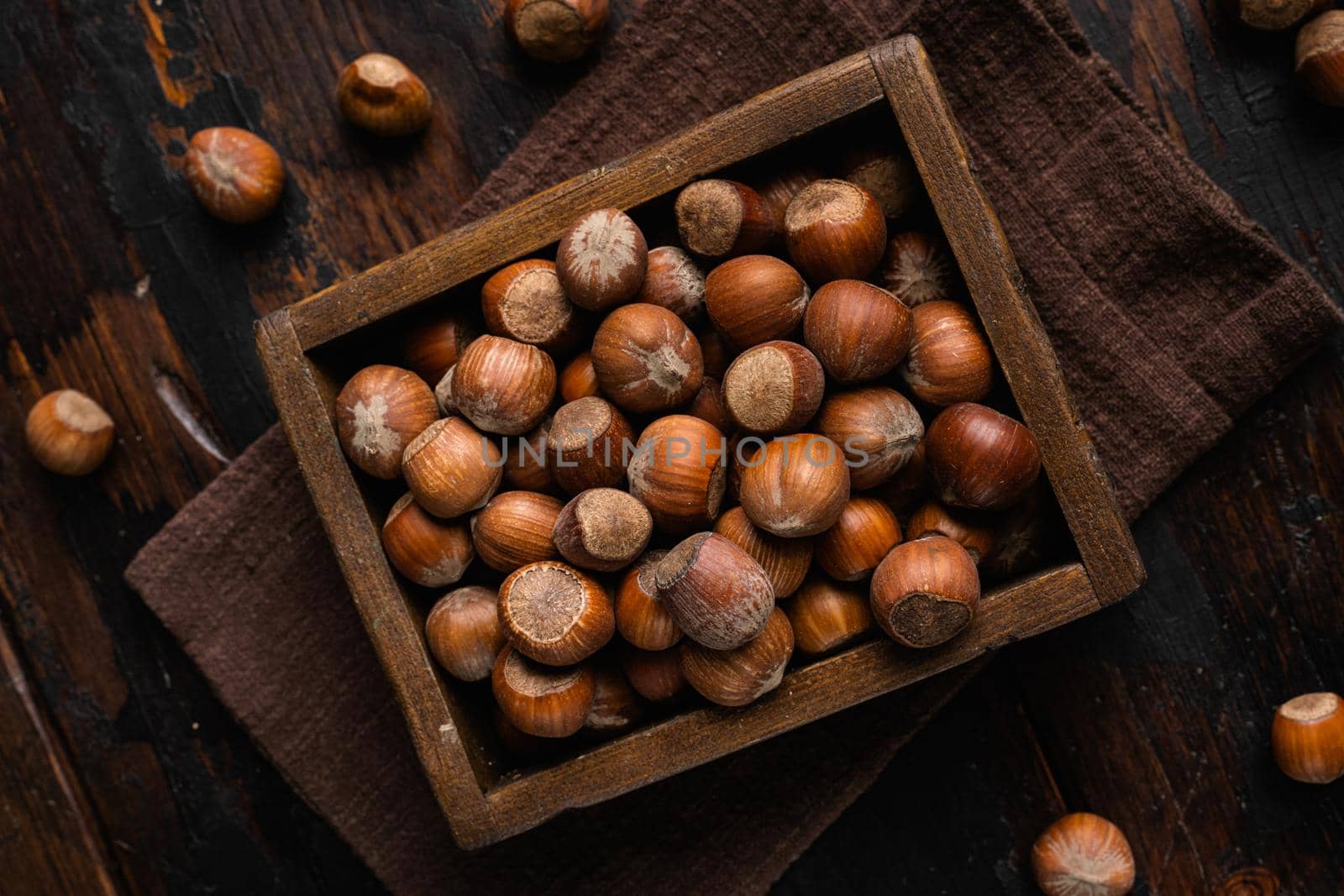 Hazelnuts brown wooden shell, on old dark wooden table background, top view flat lay by Ilianesolenyi