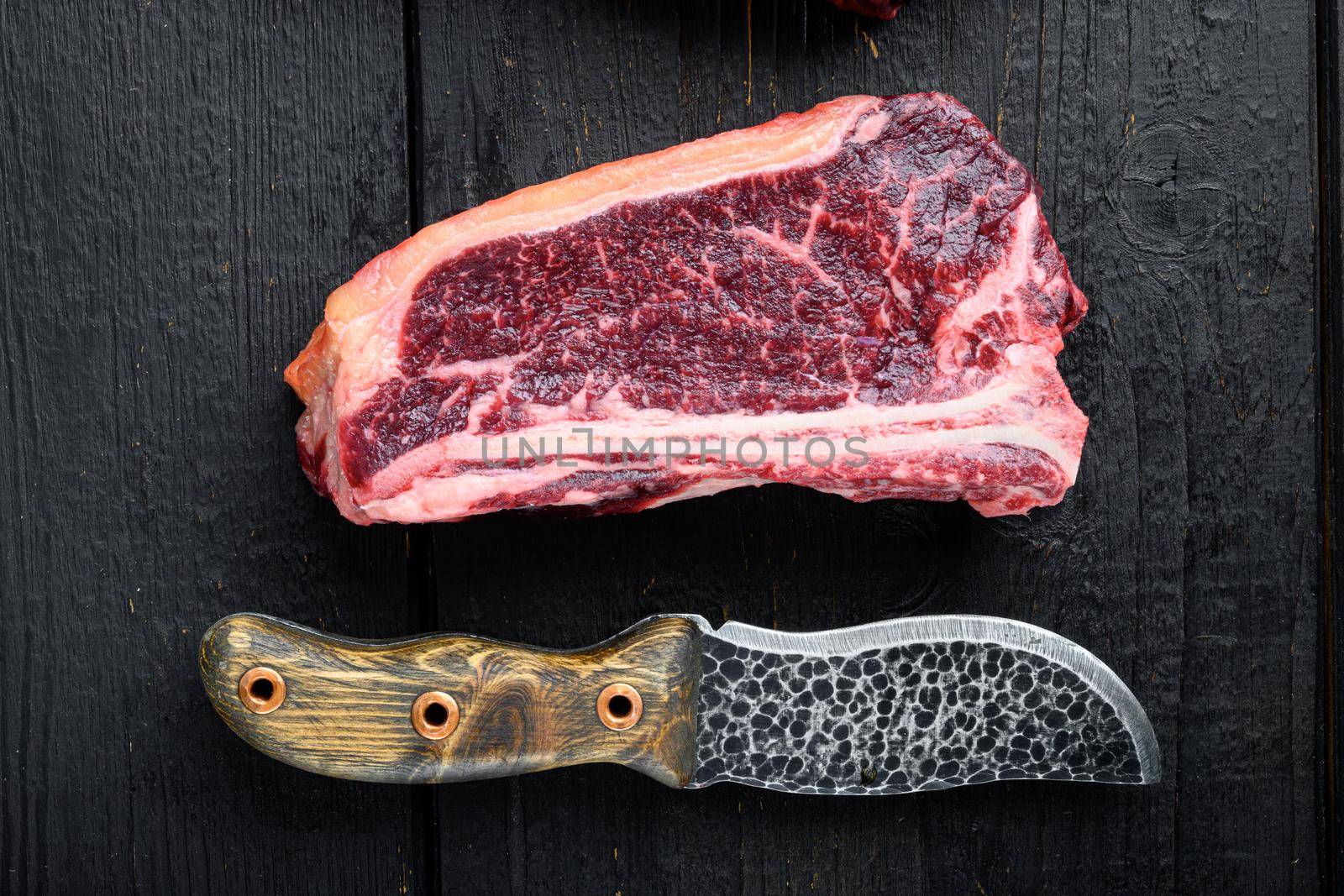 Club steak raw marbled beef meat, on black wooden table background, top view flat lay by Ilianesolenyi