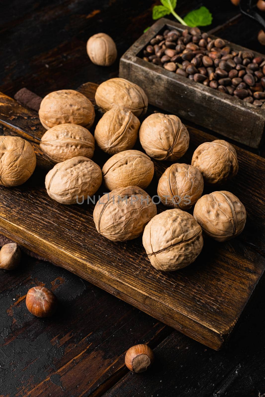 Whole organic walnuts, on old dark wooden table background by Ilianesolenyi