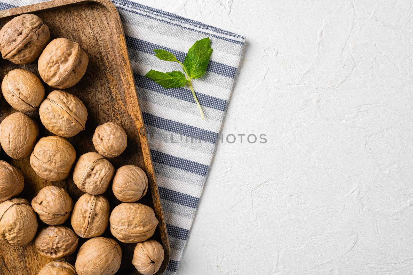 Walnuts with shells, on white stone table background, top view flat lay, with copy space for text by Ilianesolenyi