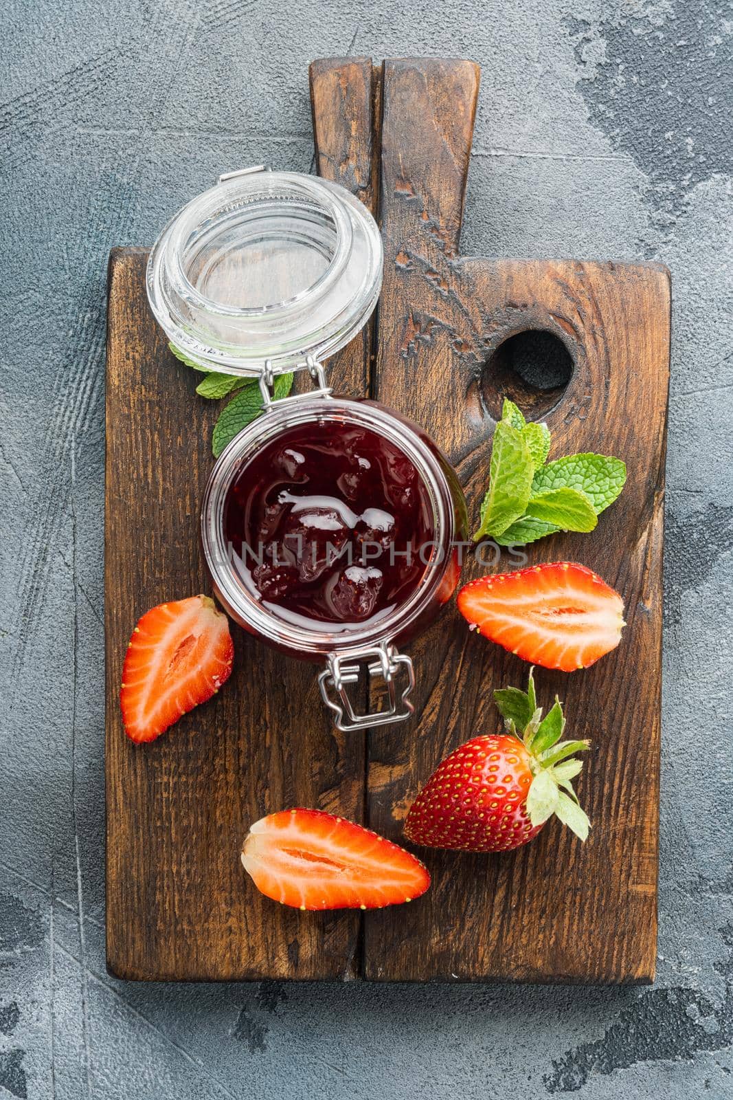 Natural strawberry jam jar, on gray background, top view flat lay