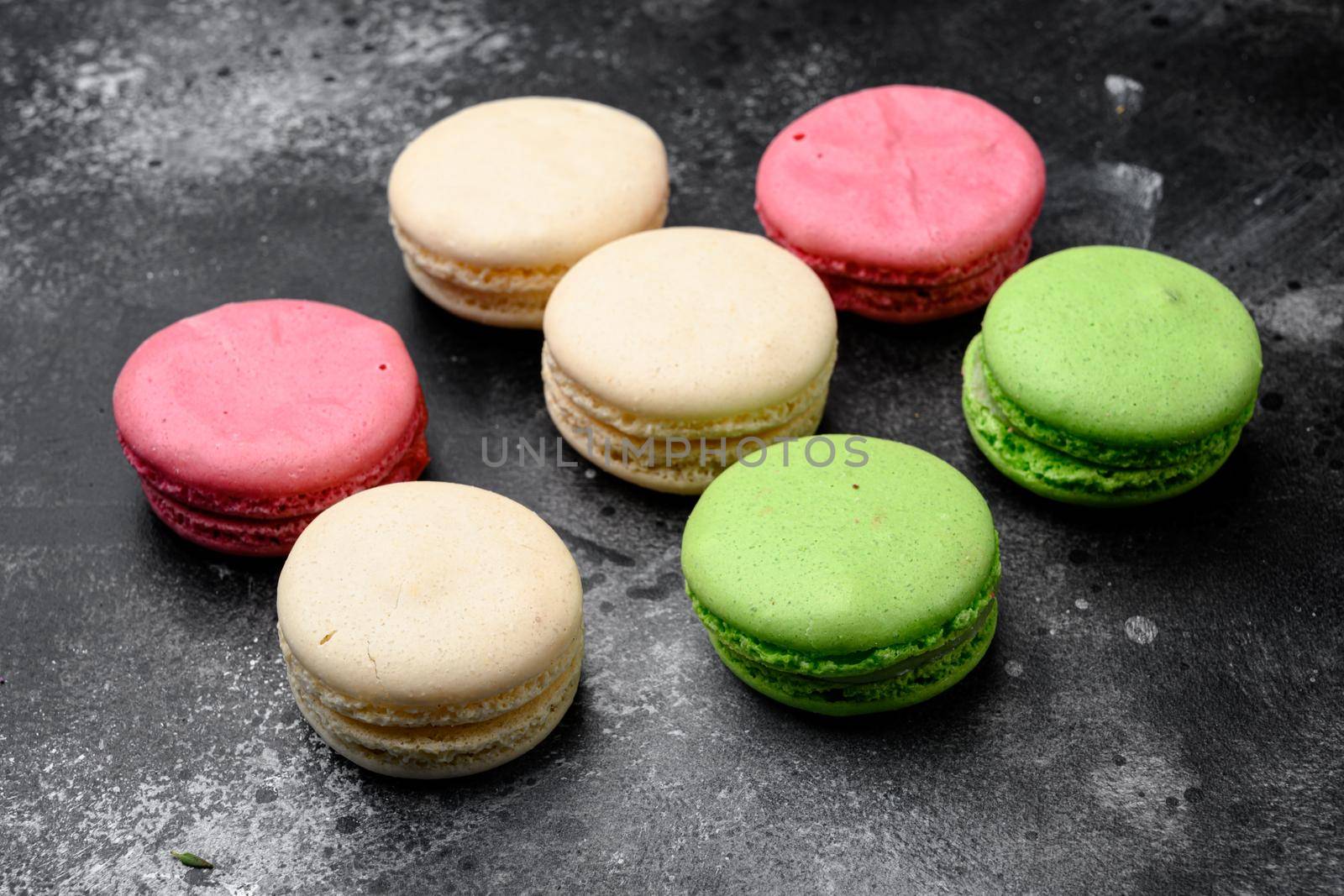 Colorful french macarons, on black dark stone table background by Ilianesolenyi