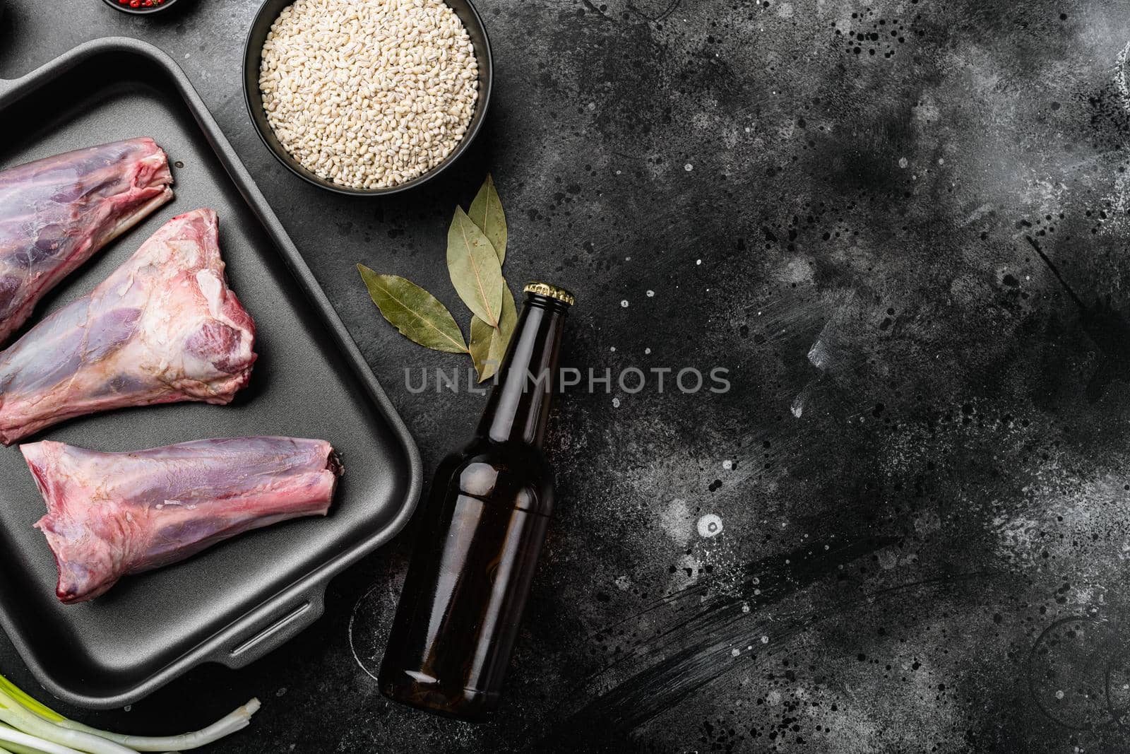 Raw Mutton shanks meat set, on black dark stone table background, top view flat lay, with copy space for text