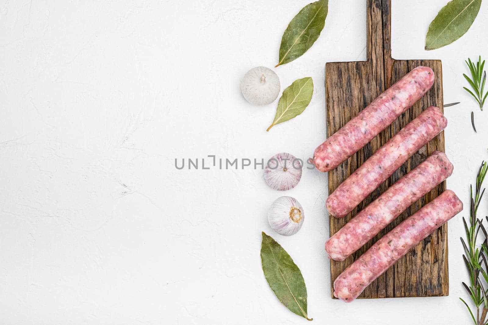 Fresh raw minced meat sausages, on white stone table background, top view flat lay, with copy space for text by Ilianesolenyi