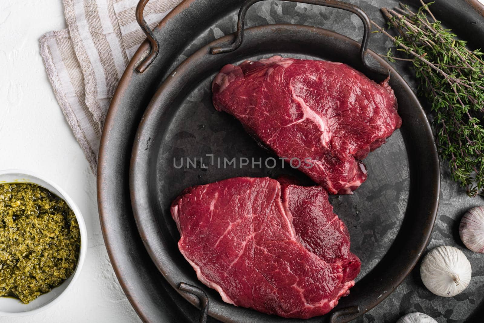 Raw cap rump steak set, on white stone table background, top view flat lay