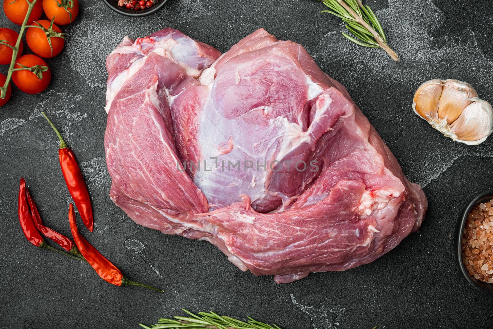 Raw slice of Iberian pork with ingredients, on black dark stone table background, top view flat lay by Ilianesolenyi