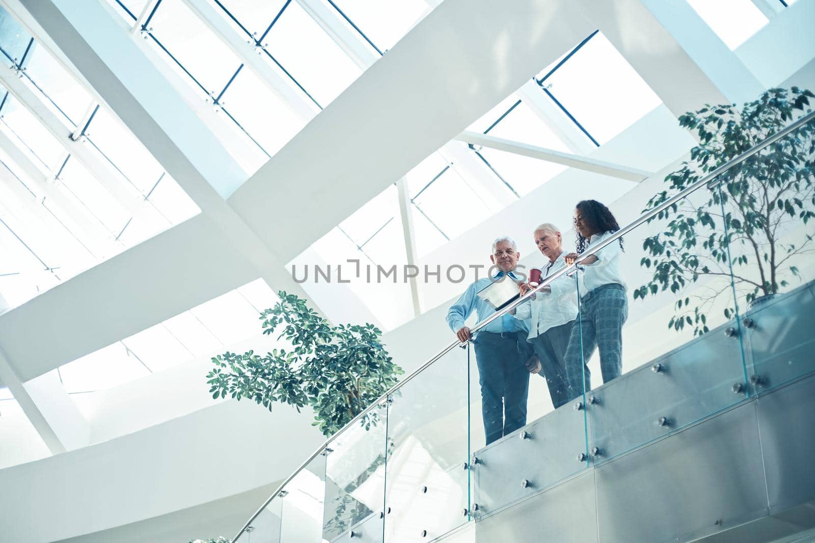 group of business people standing on the balcony of a business center. by SmartPhotoLab