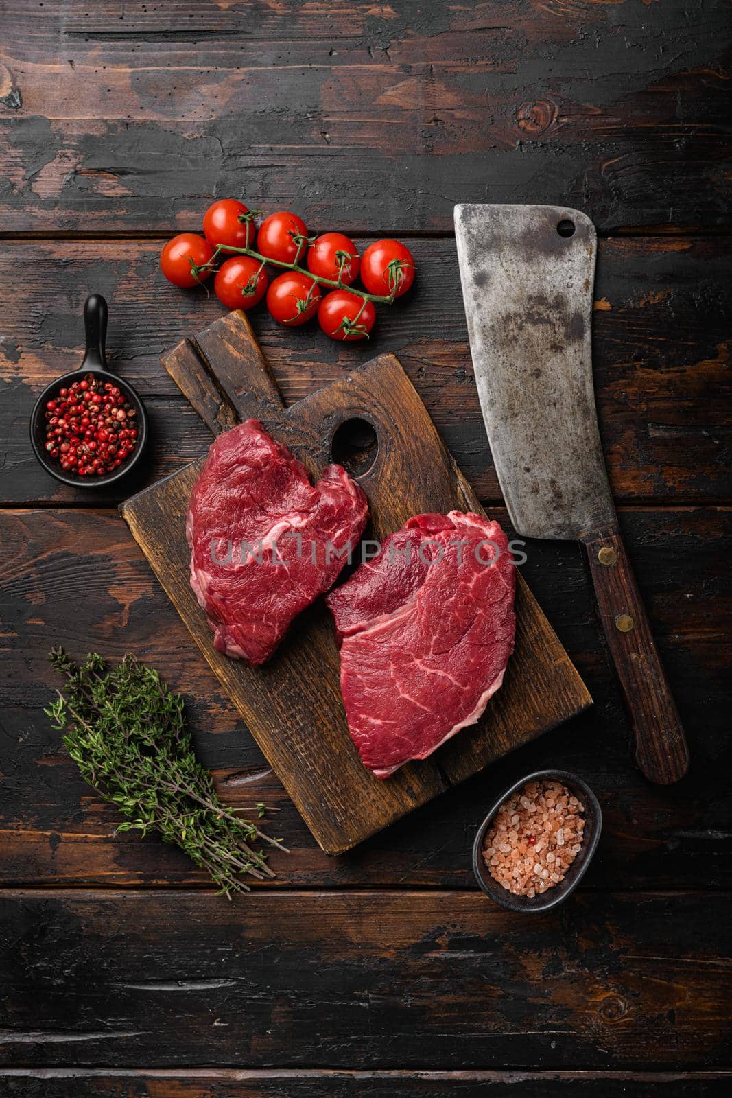 Beef raw rump steak with salt pepper rosemary, on old dark wooden table background, top view flat lay by Ilianesolenyi