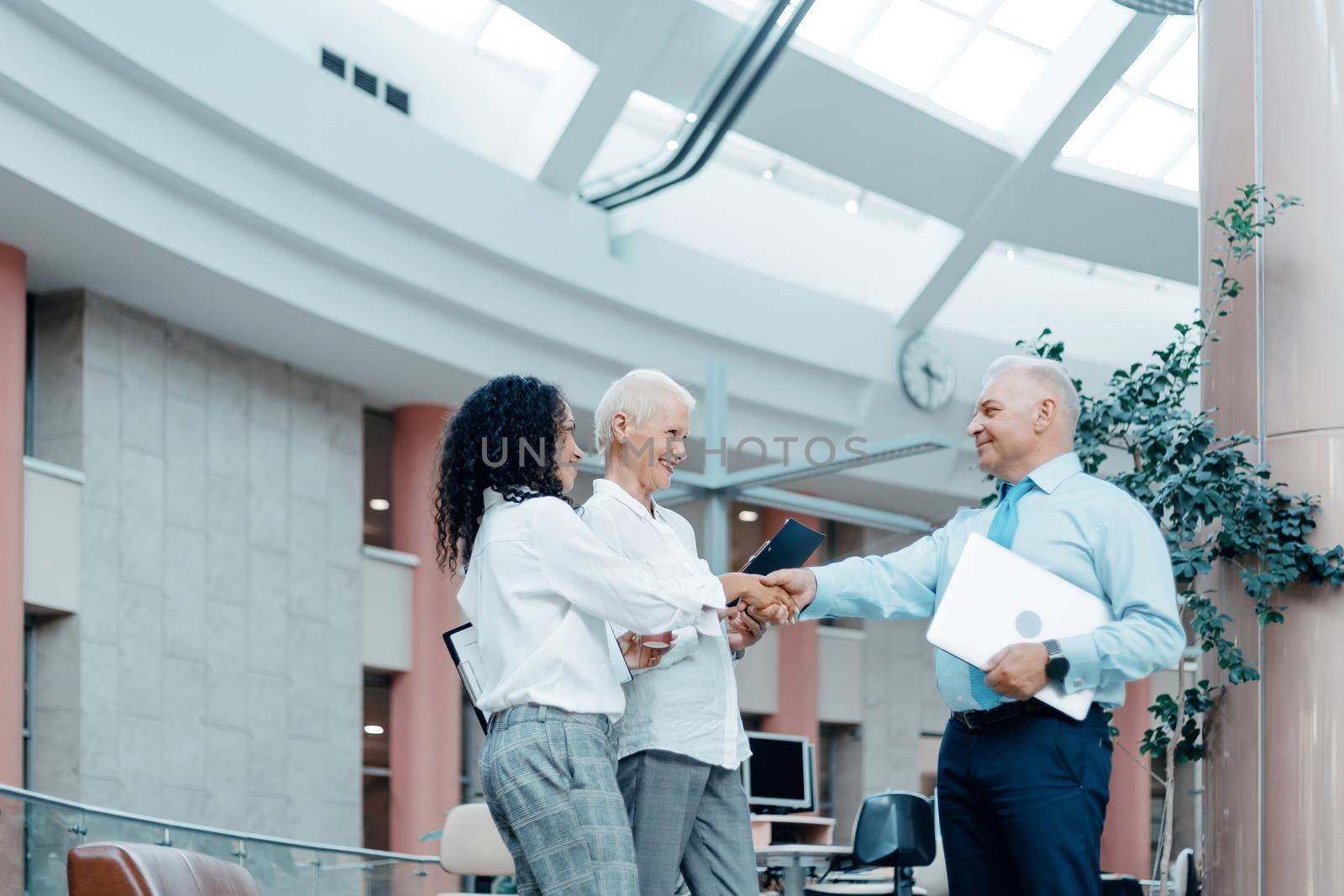 smiling businessman and businesswoman meeting each other with a handshake . by SmartPhotoLab