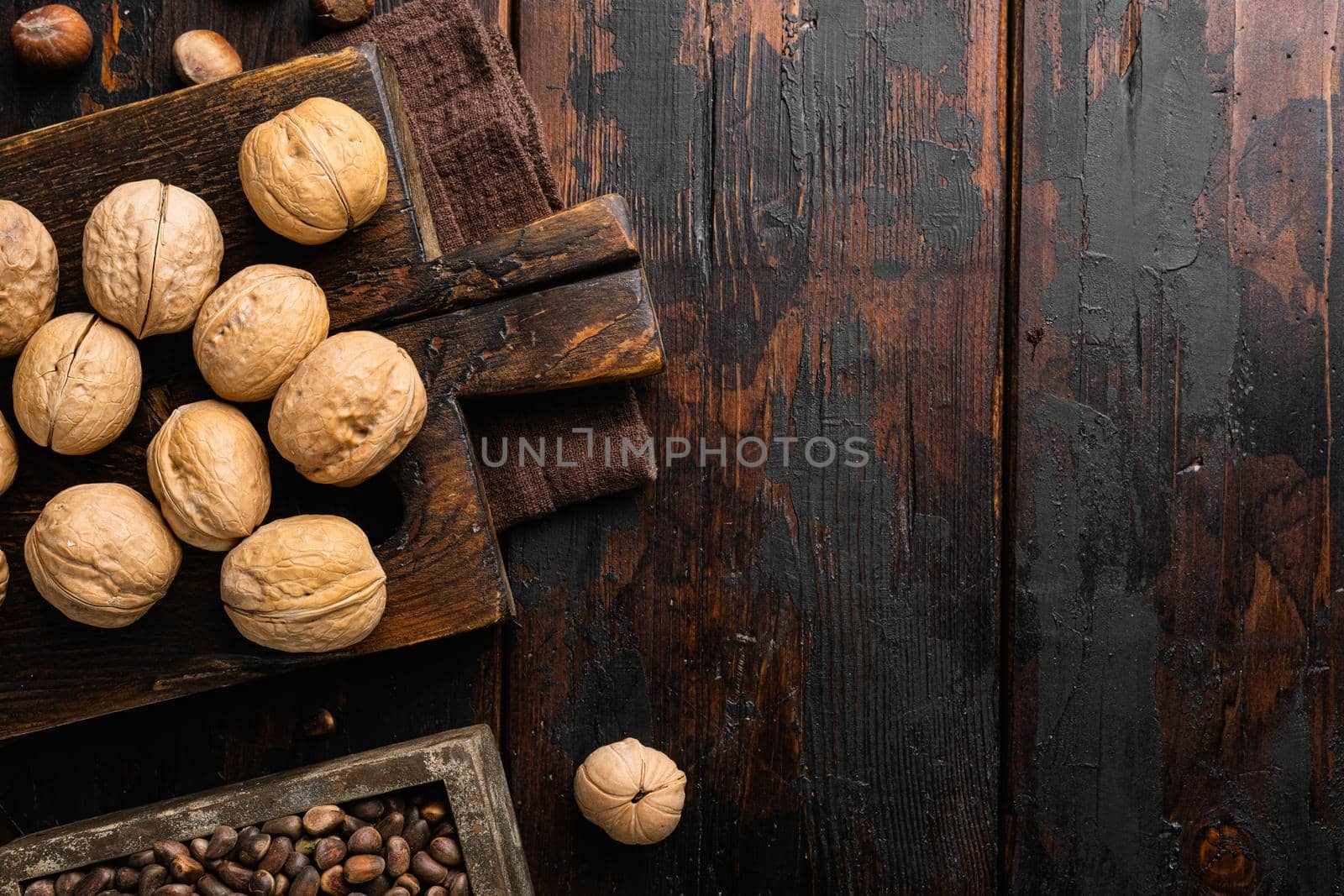 Natural walnut set, on old dark wooden table background, top view flat lay, with copy space for text