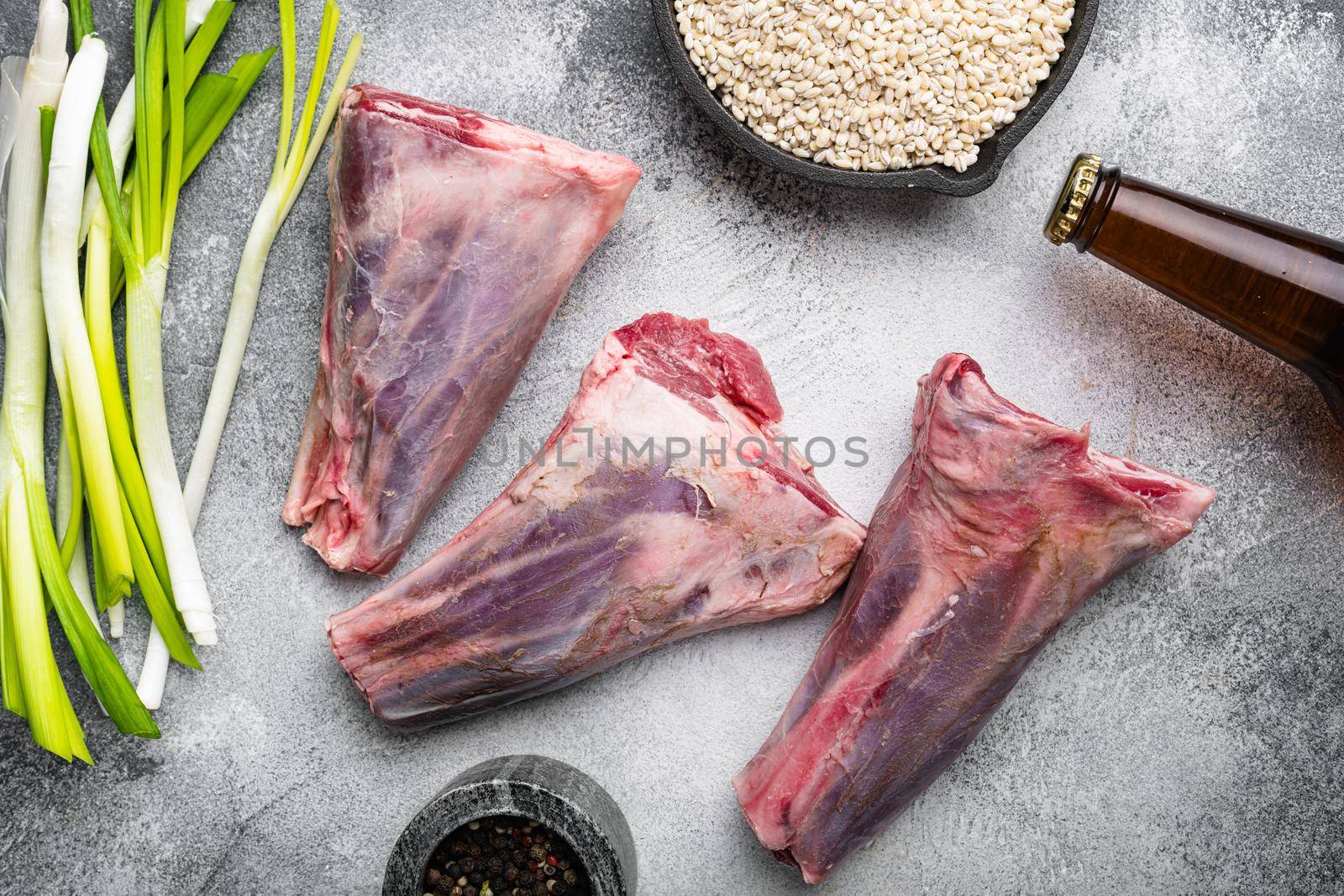 Uncooked lamb shank, on gray stone table background, top view flat lay by Ilianesolenyi