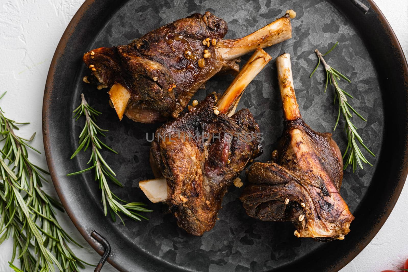 Baked lamb shank meat, on white stone table background, top view flat lay by Ilianesolenyi