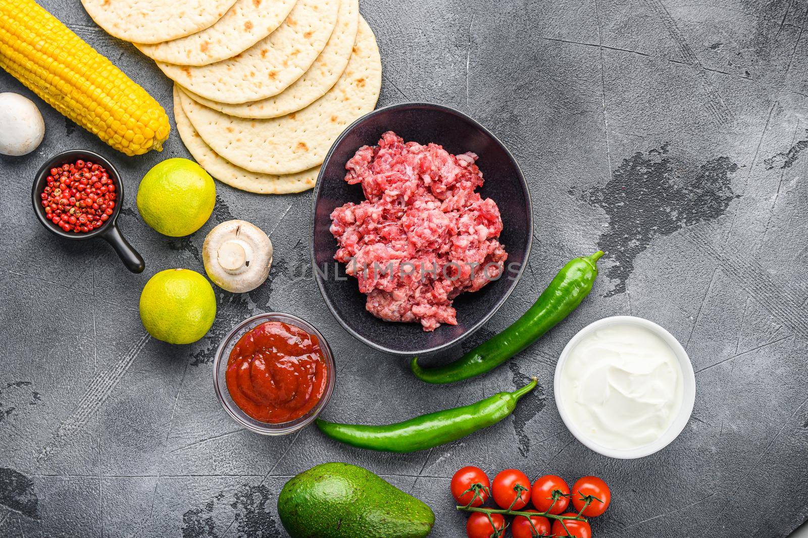 Traditional homemade taco ingredients with meat over grey background, top view. by Ilianesolenyi