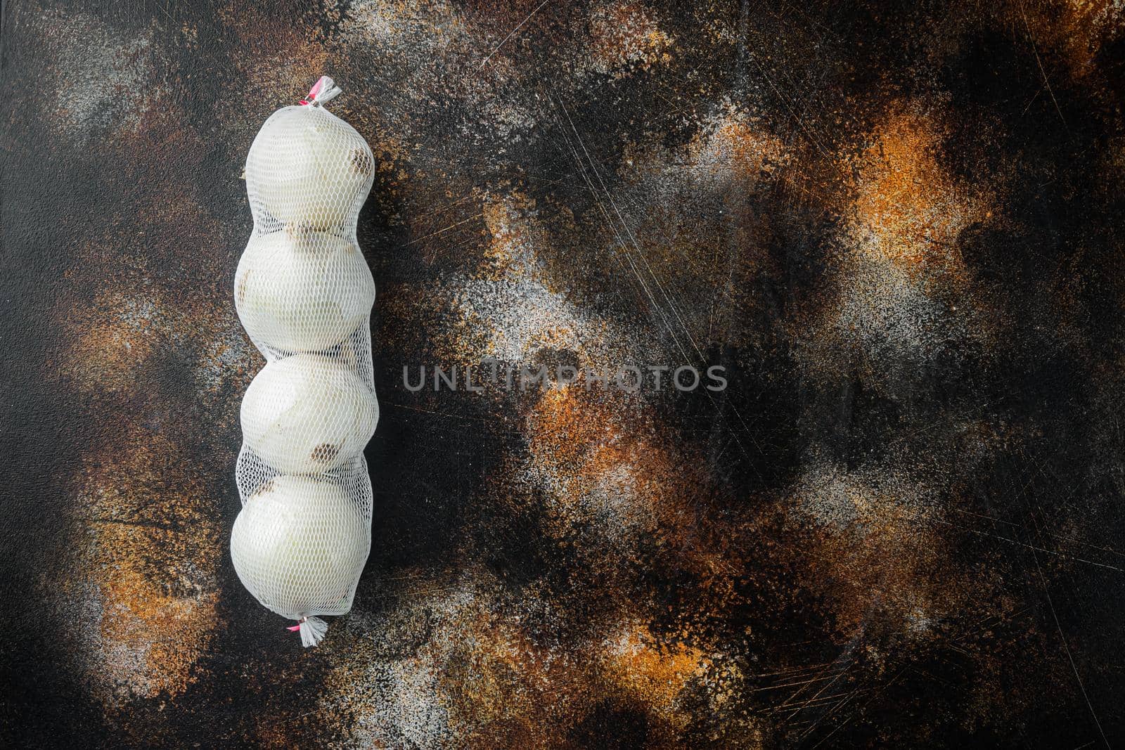 Homegrown white onions, on old dark rustic background, top view flat lay with copy space for text