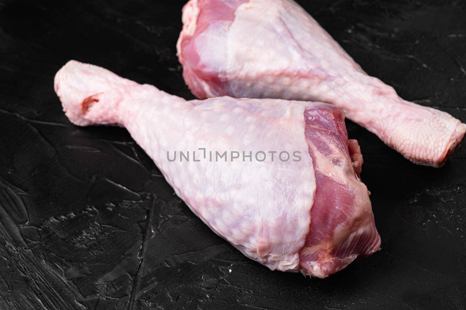 Raw turkey legs ingredients, on black dark stone table background by Ilianesolenyi