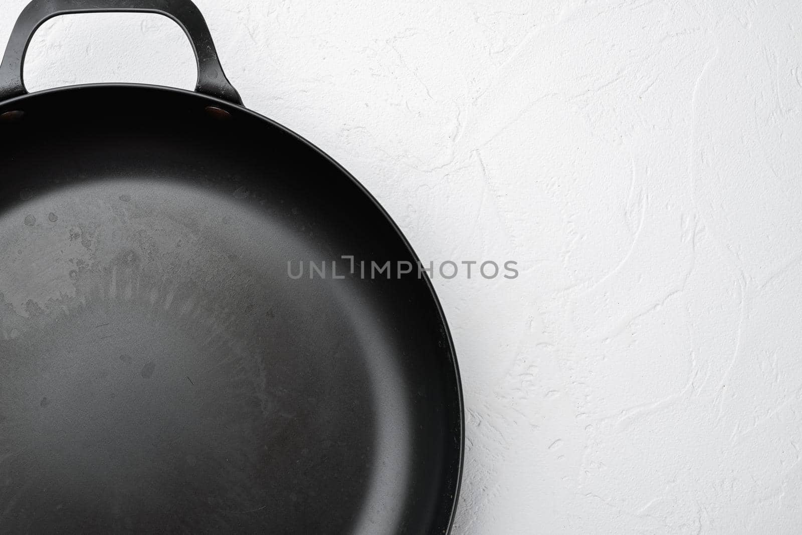 Vintage cast iron skillet with copy space for text or food with copy space for text or food, top view flat lay , on white stone table background by Ilianesolenyi