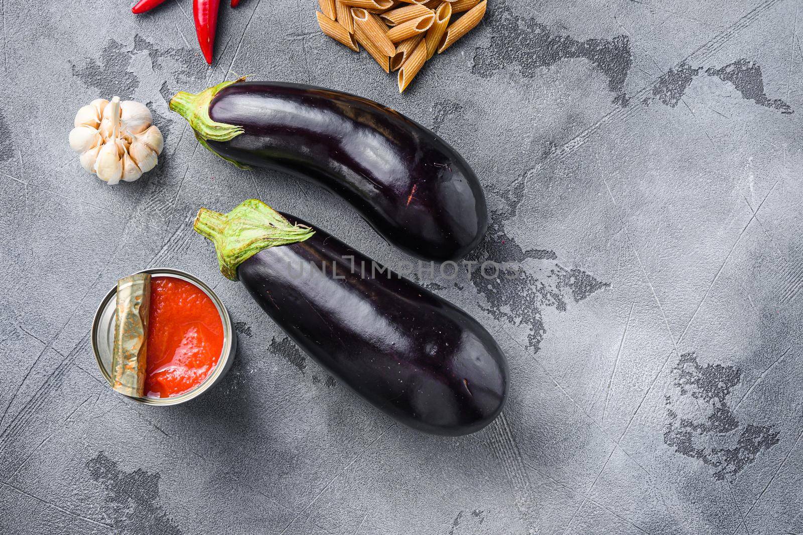 Aubergine penne ingredients eggplant pasta, pepper tomatoe sauce, on grey background top view space for text