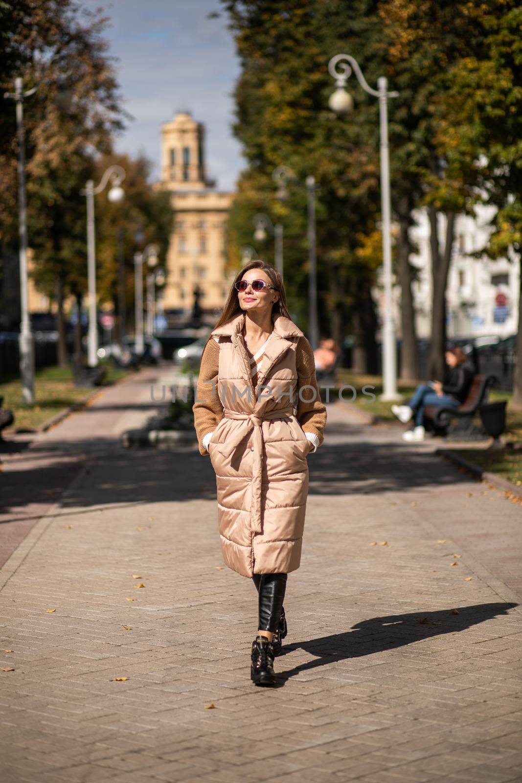 pretty caucasian female advertising winter clothes and boots in the park