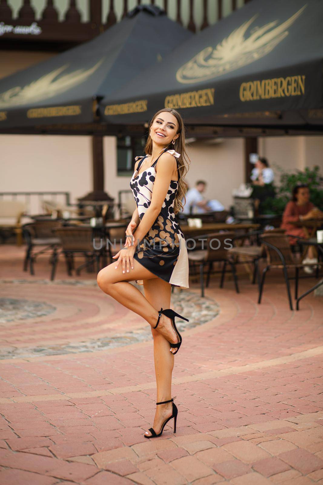 cheerful female model posing to the camera near the cafe outside by StudioLucky