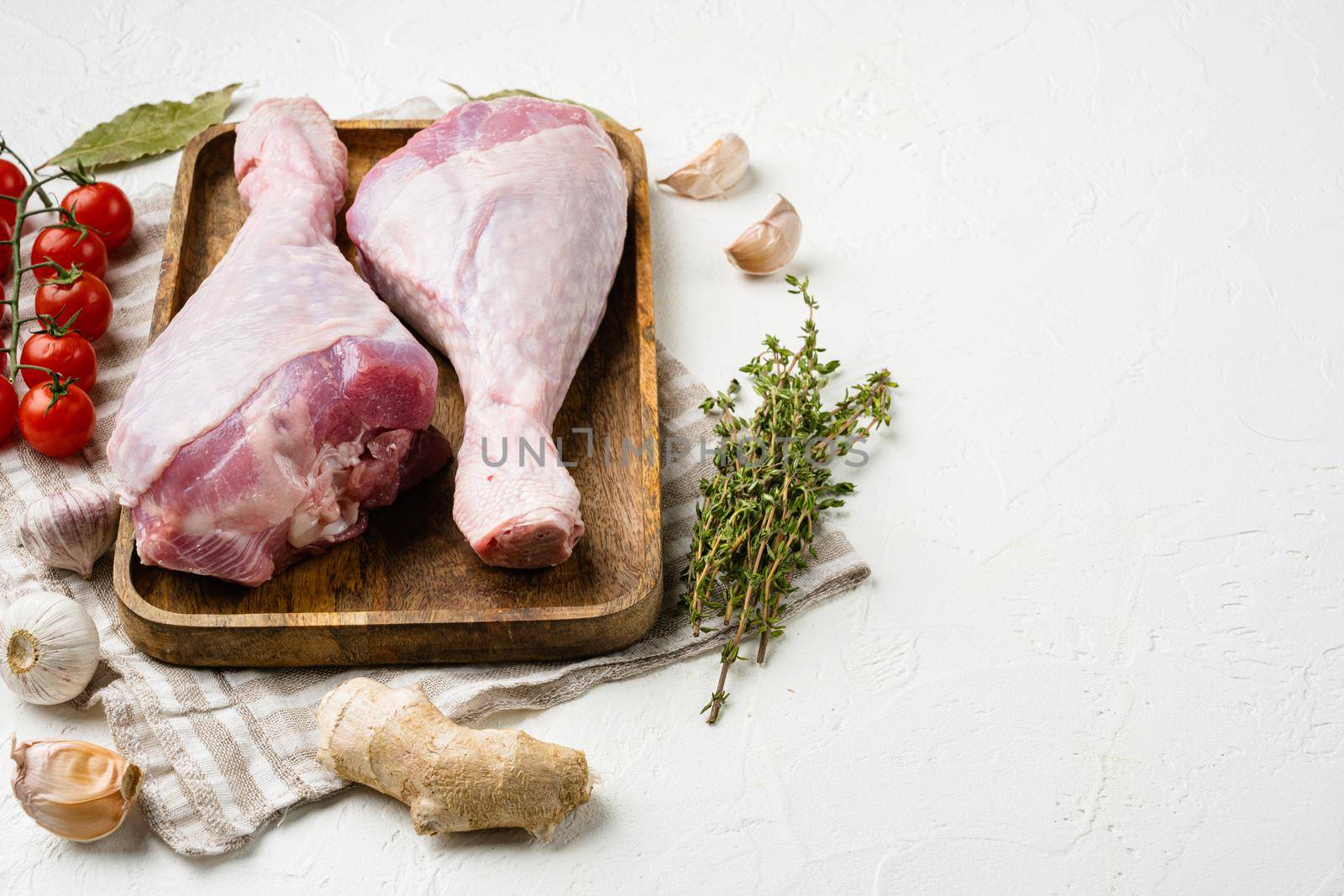 Turkey drumstick fresh meat set, on white stone table background, with copy space for text