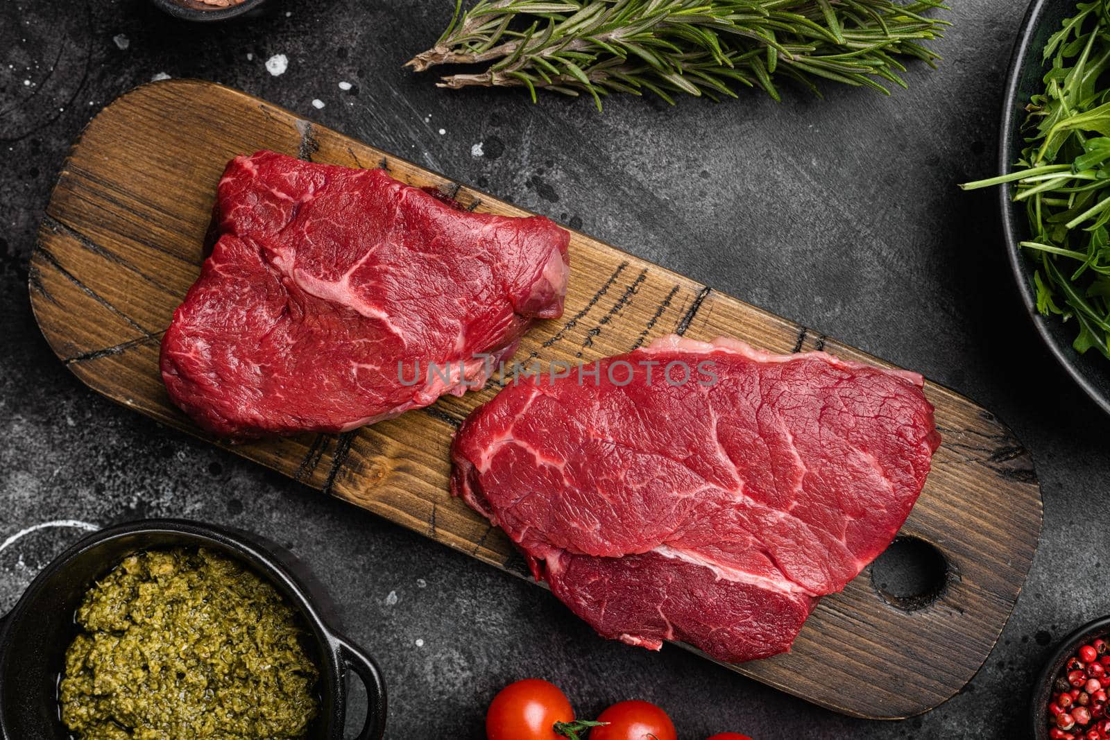 Raw seasoned rump steaks beef meat set, on black dark stone table background, top view flat lay