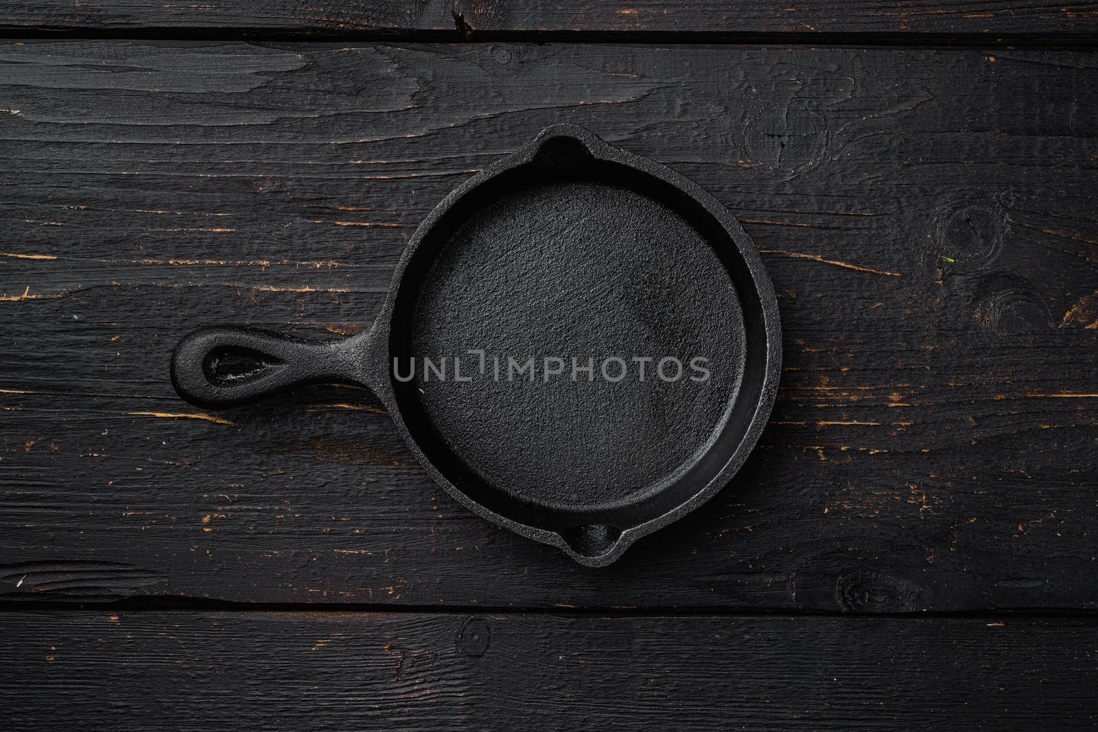 Used old empty frying pan set with copy space for text or food with copy space for text or food, top view flat lay, on black wooden table background