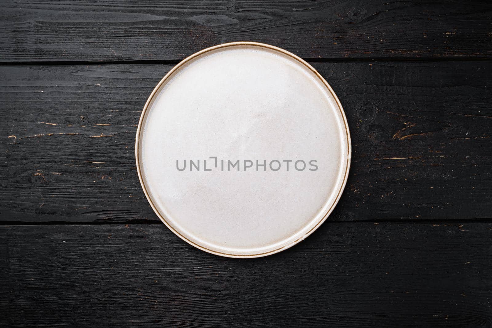 Empty ceramic plate set with copy space for text or food with copy space for text or food, top view flat lay, on black wooden table background