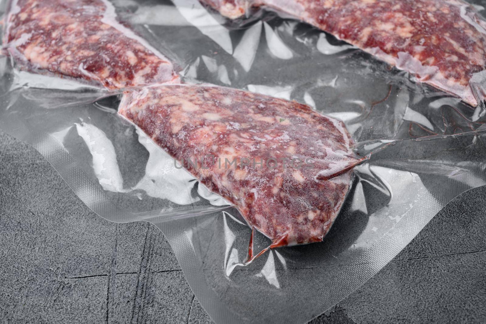 Beef patties in a vacuum packing, on gray stone table background, with copy space for text