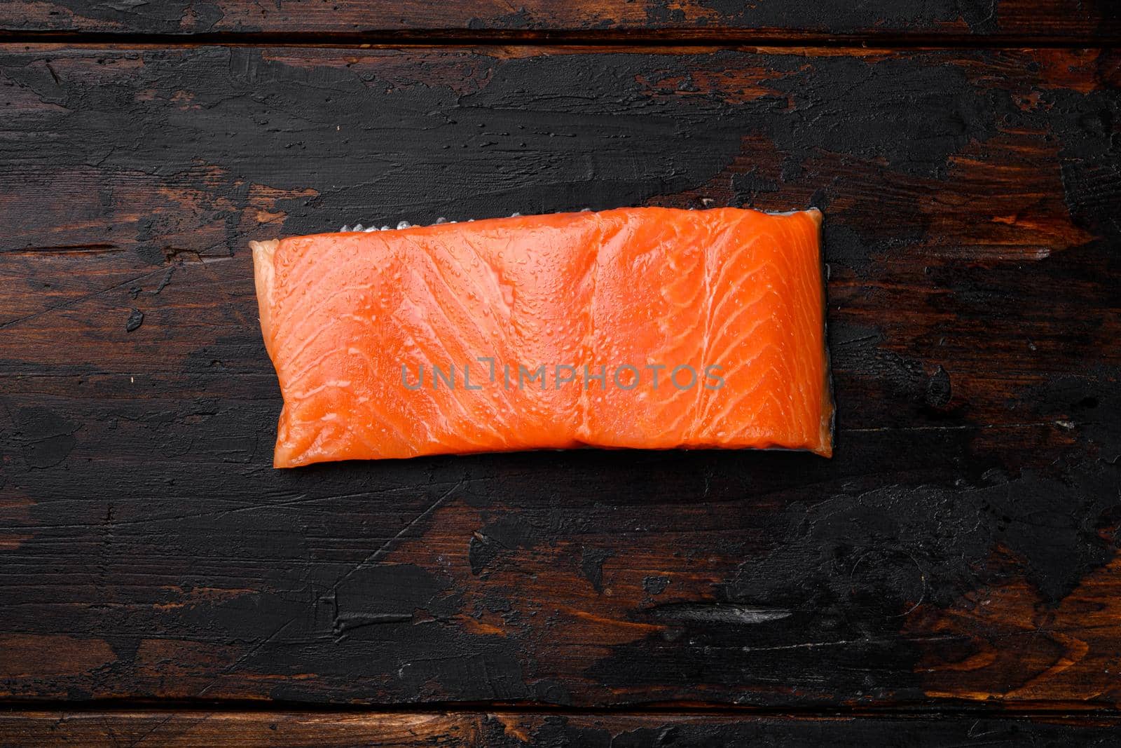 Raw Fillet of salmon, on old dark wooden table background, top view flat lay, with copy space for text by Ilianesolenyi