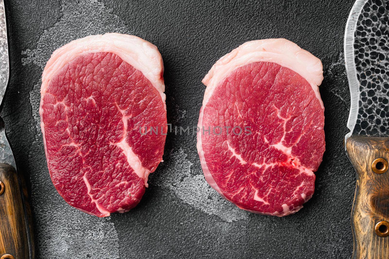 Raw tenderloin steak set, on black dark stone table background, top view flat lay