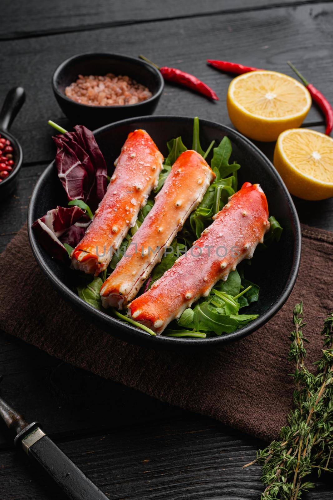 Snow crab legs, on black wooden table background by Ilianesolenyi