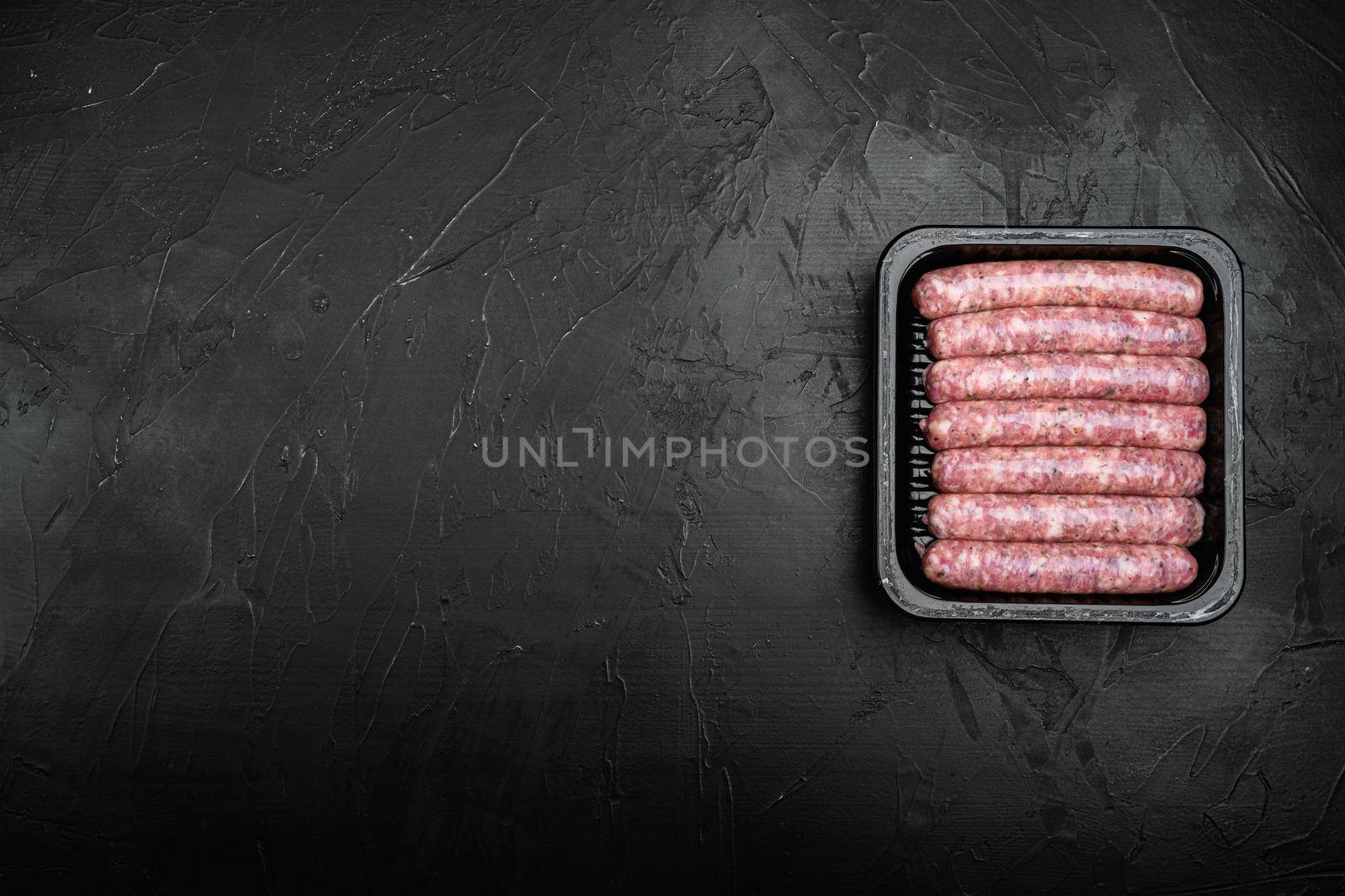 Flesh meat product for cooking packed in box set, on black dark stone table background, top view flat lay, with copy space for text