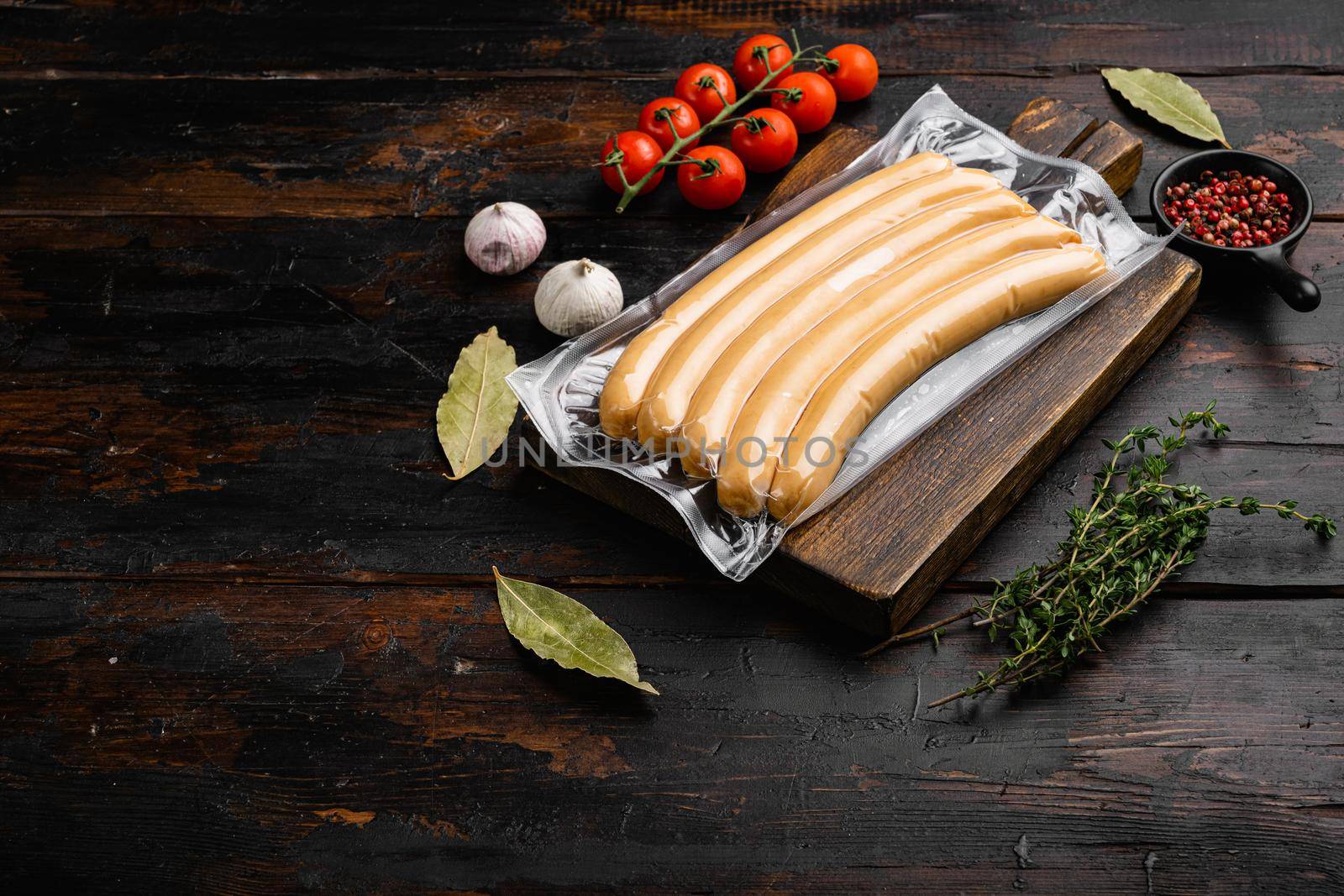 Packing sausages, on old dark wooden table background, with copy space for text by Ilianesolenyi