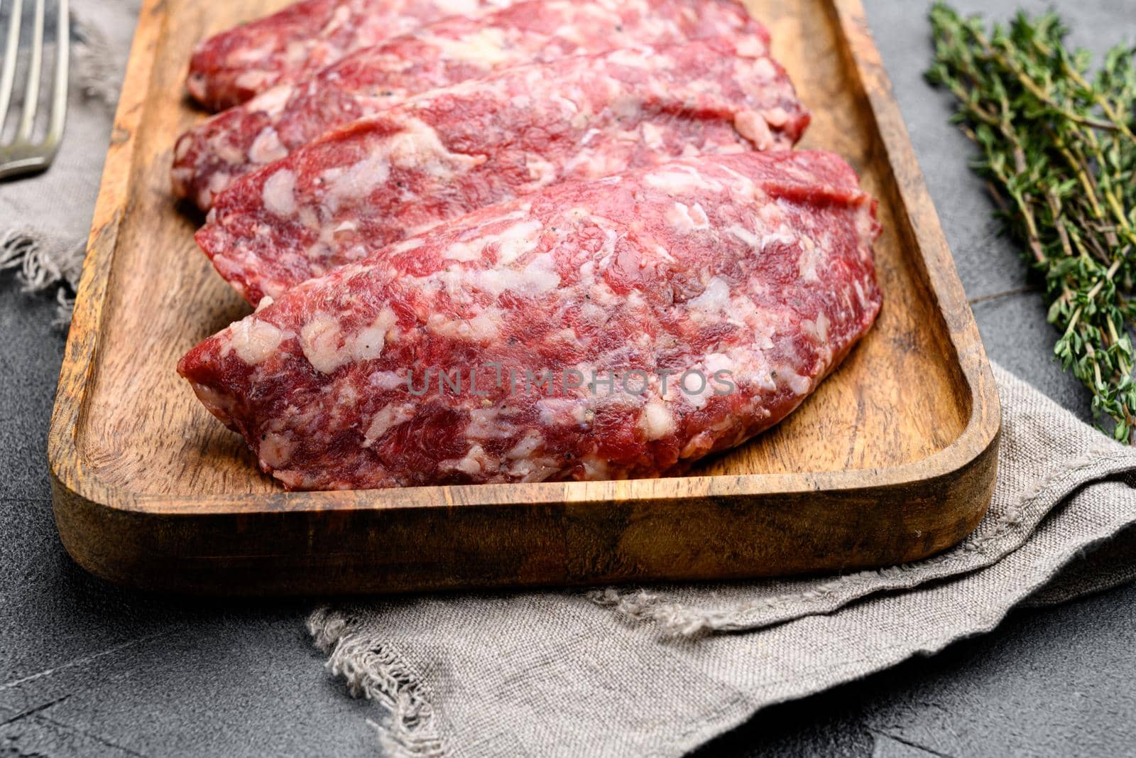 Raw beef patty, on gray stone table background by Ilianesolenyi