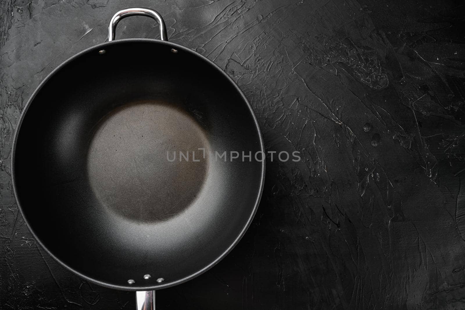 Pan with handle wok set with copy space for text or food with copy space for text or food, top view flat lay, on black dark stone table background