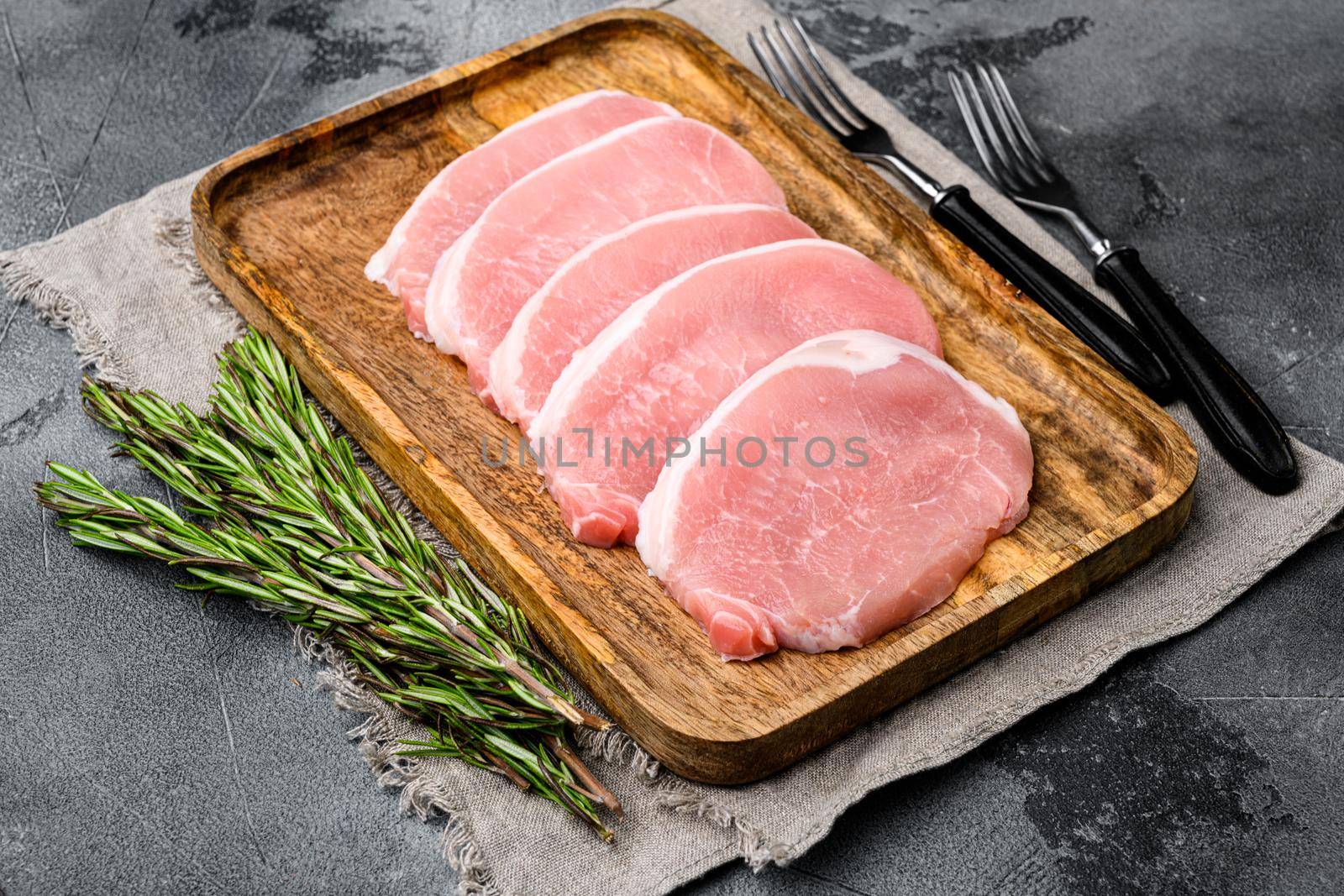 Pork steaks Raw meat, on gray stone table background by Ilianesolenyi