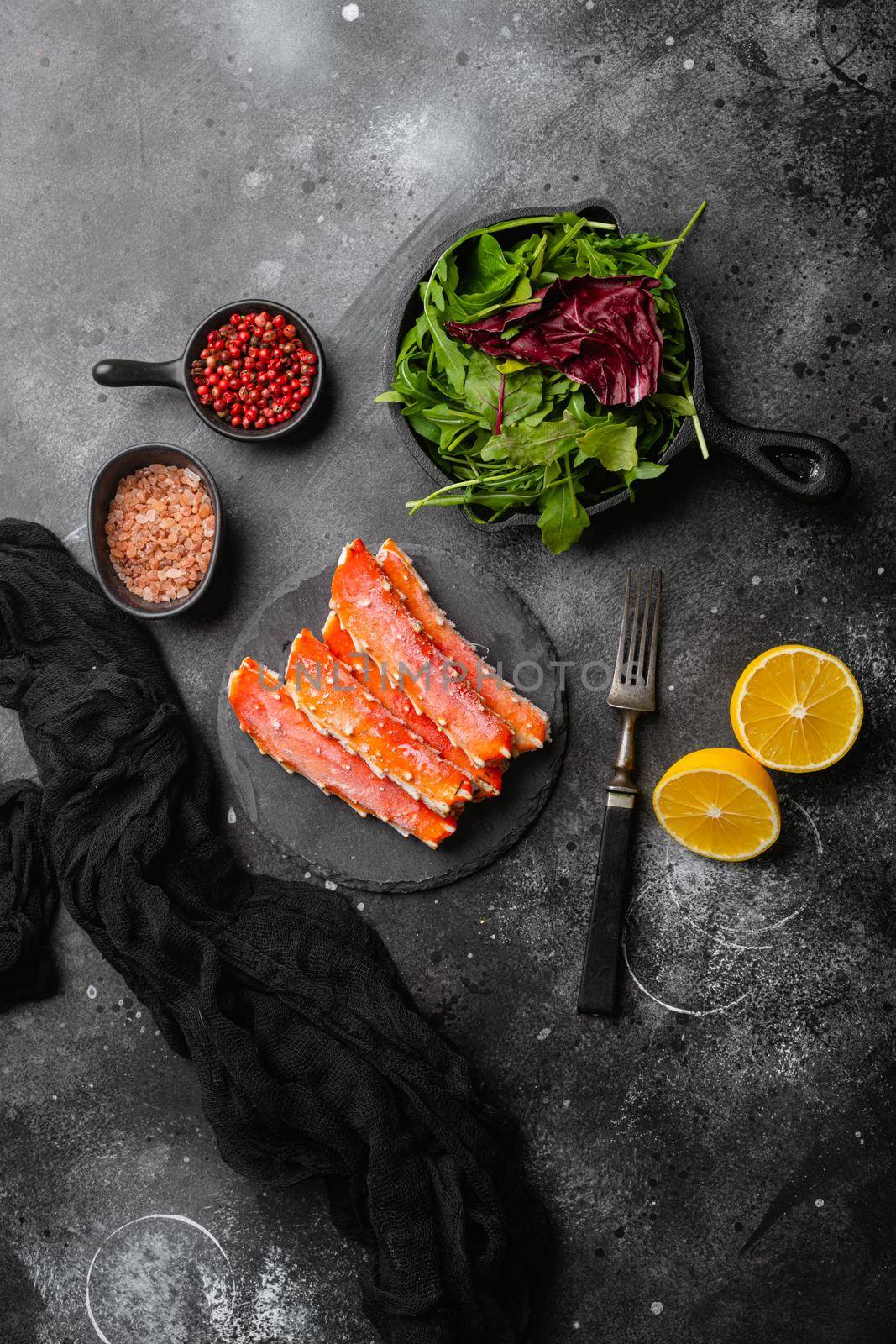 Fresh frozen organic crab legs, on black dark stone table background, top view flat lay, with copy space for text by Ilianesolenyi