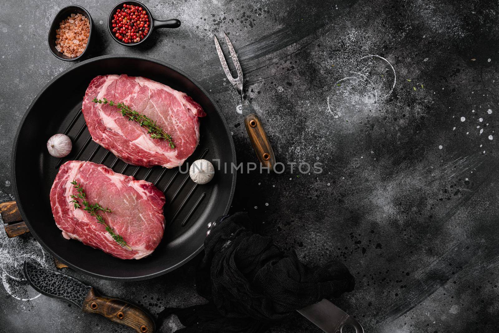 Raw fresh marbled meat Steak Ribeye, on black dark stone table background, top view flat lay, with copy space for text by Ilianesolenyi