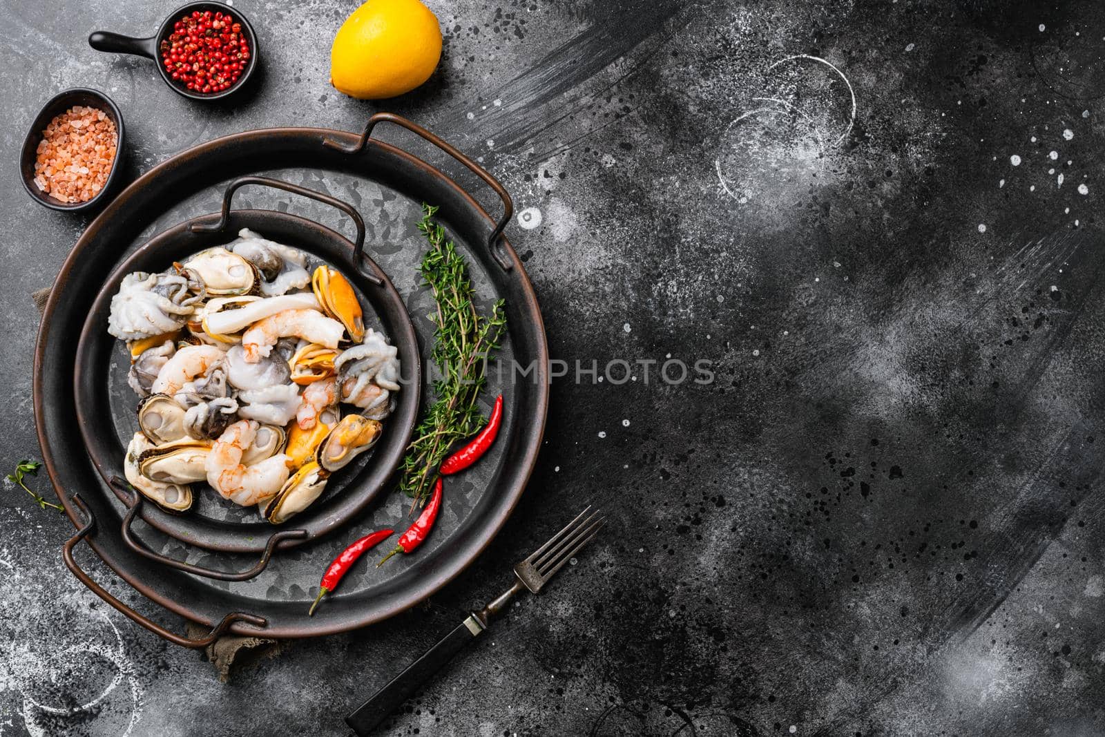 Seafood board with shrimp, squid mussel and octopus, on black dark stone table background, top view flat lay, with copy space for text by Ilianesolenyi