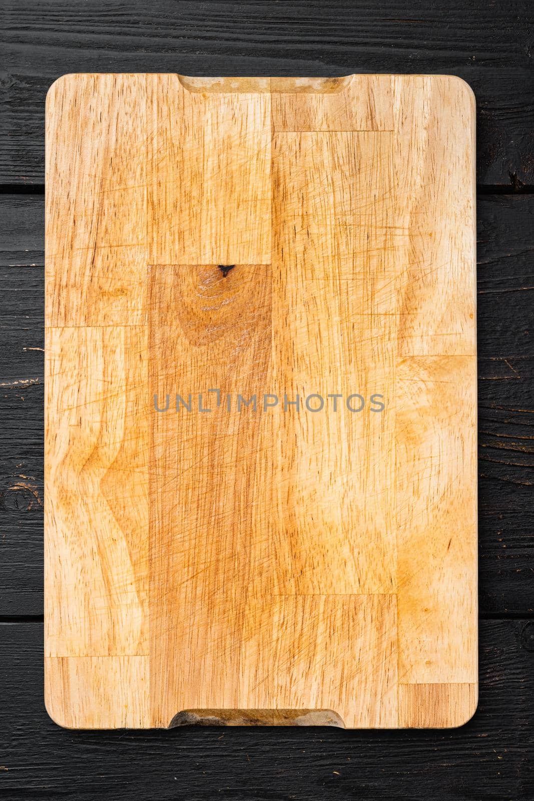 Wooden cutting board, on black wooden table background, top view flat lay , with copy space for text or your product by Ilianesolenyi