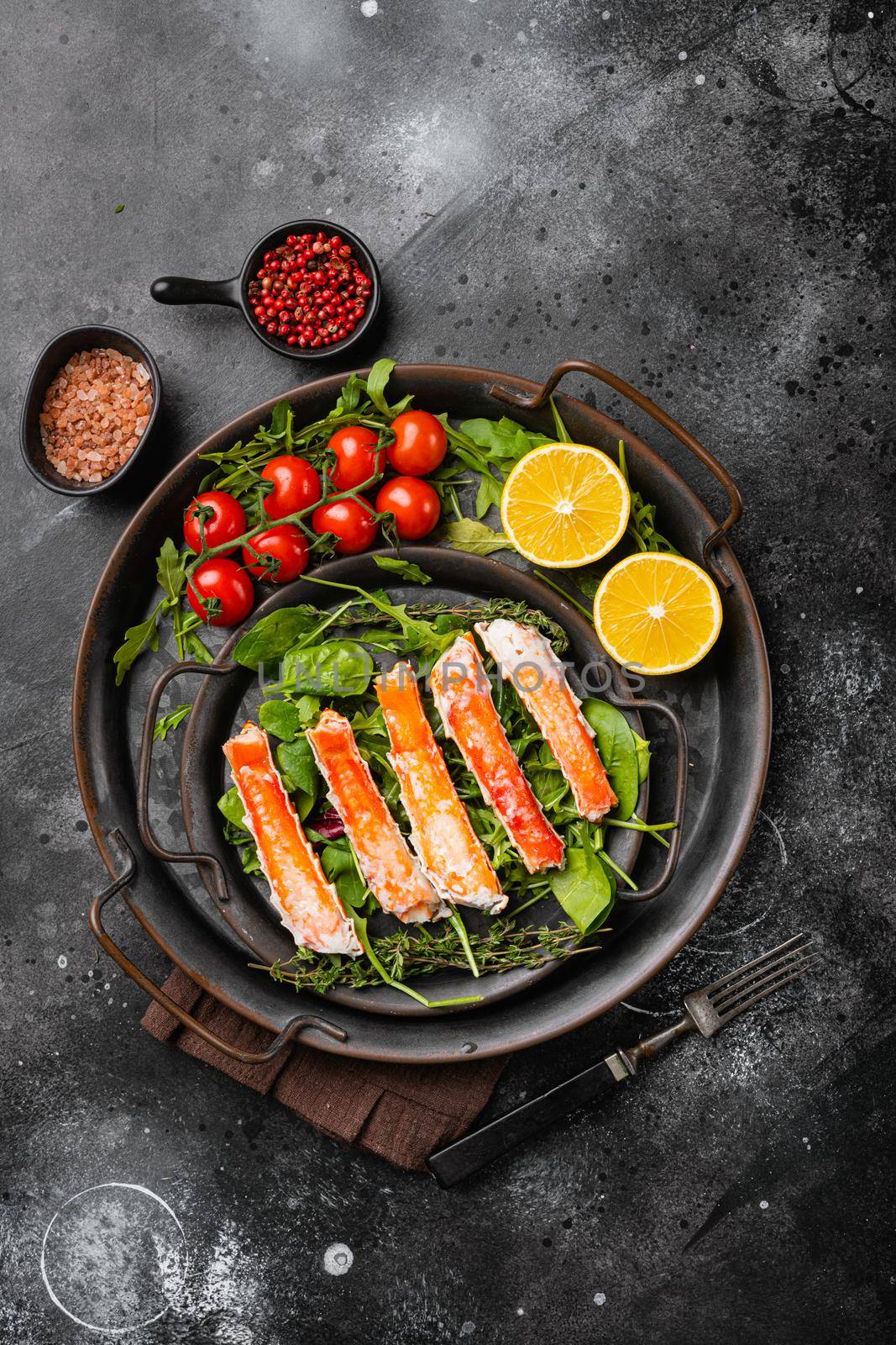 Cooked King Crab legs meat set, on black dark stone table background, top view flat lay, with copy space for text