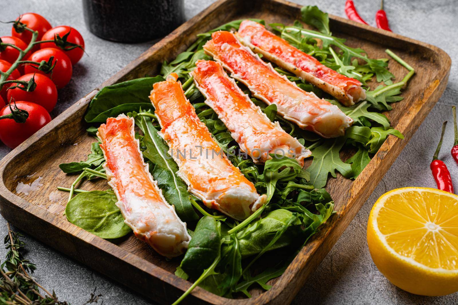 Crab leg meat in a shell with herbs set, on gray stone table background