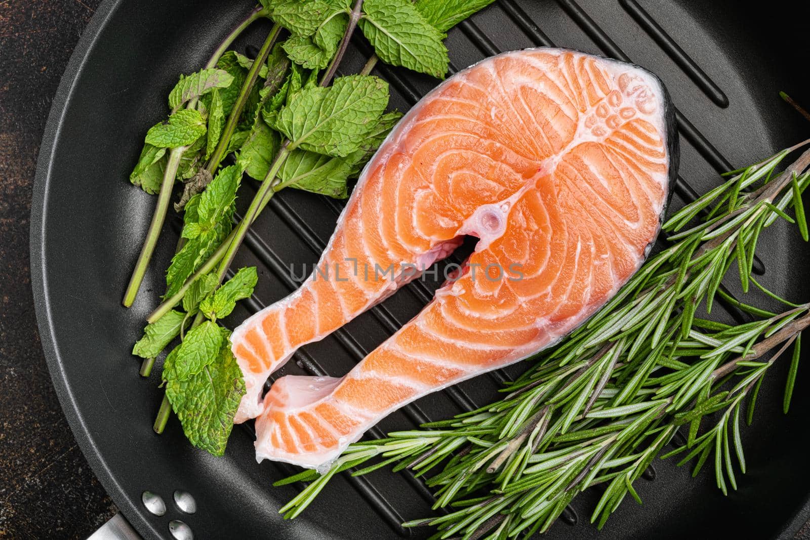 Raw salmon fish fillet with fresh herbs, in cast iron frying pan, top view flat lay by Ilianesolenyi