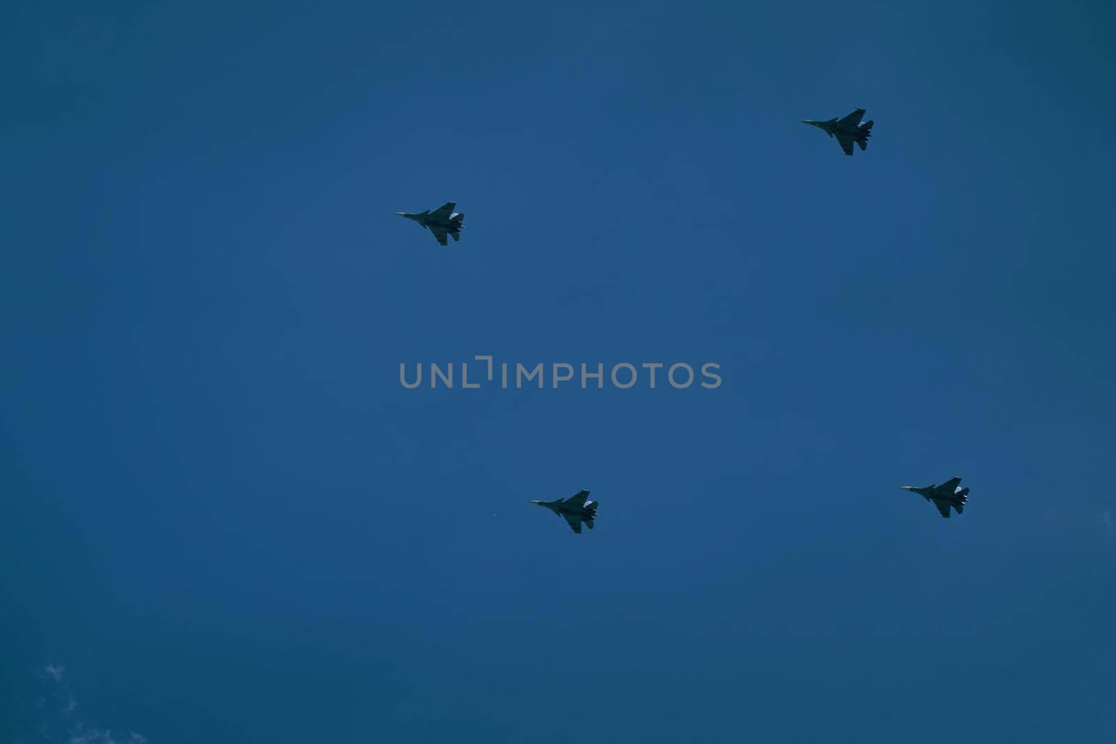 Victory parade of military aircraft over the city. Representation of aviation equipment. Group of army air force shows aerobatics in blue sky.