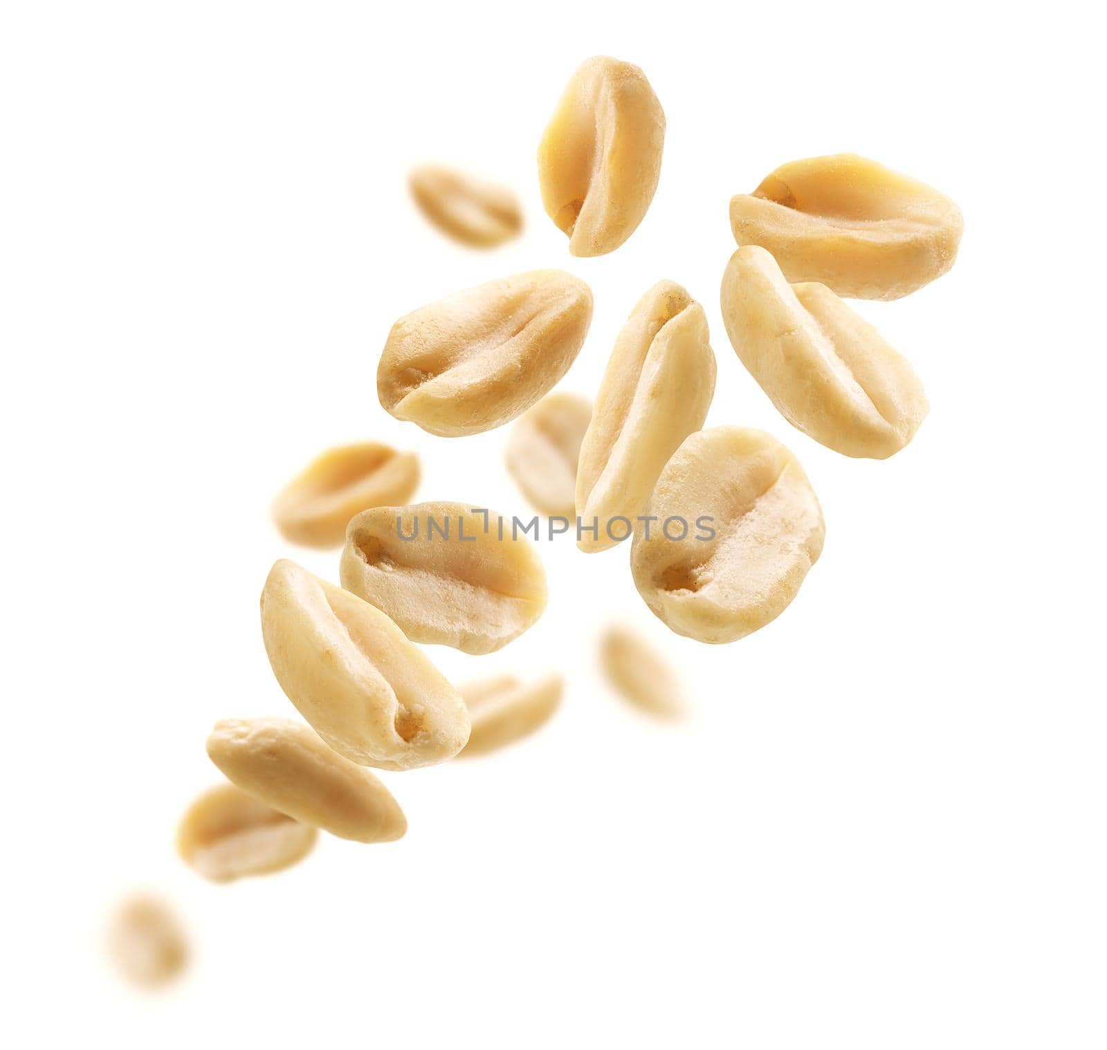 Peeled peanuts levitate on a white background.