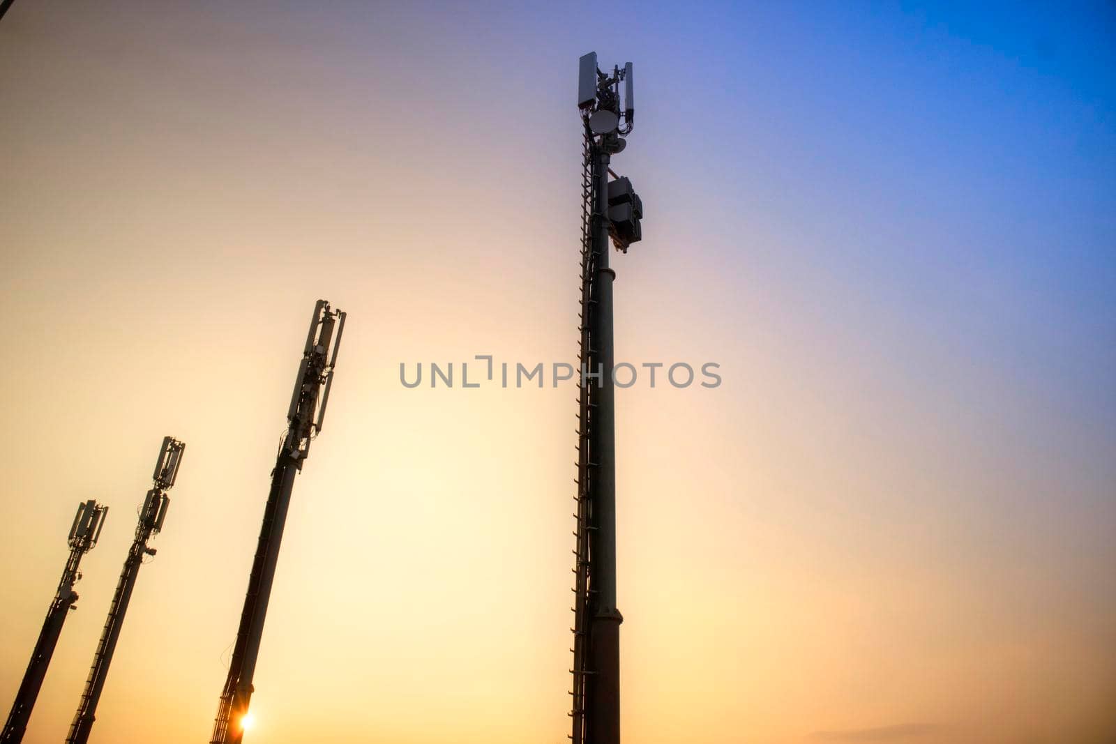 Sunrise photo shoot of mobile phone poles backlit image 